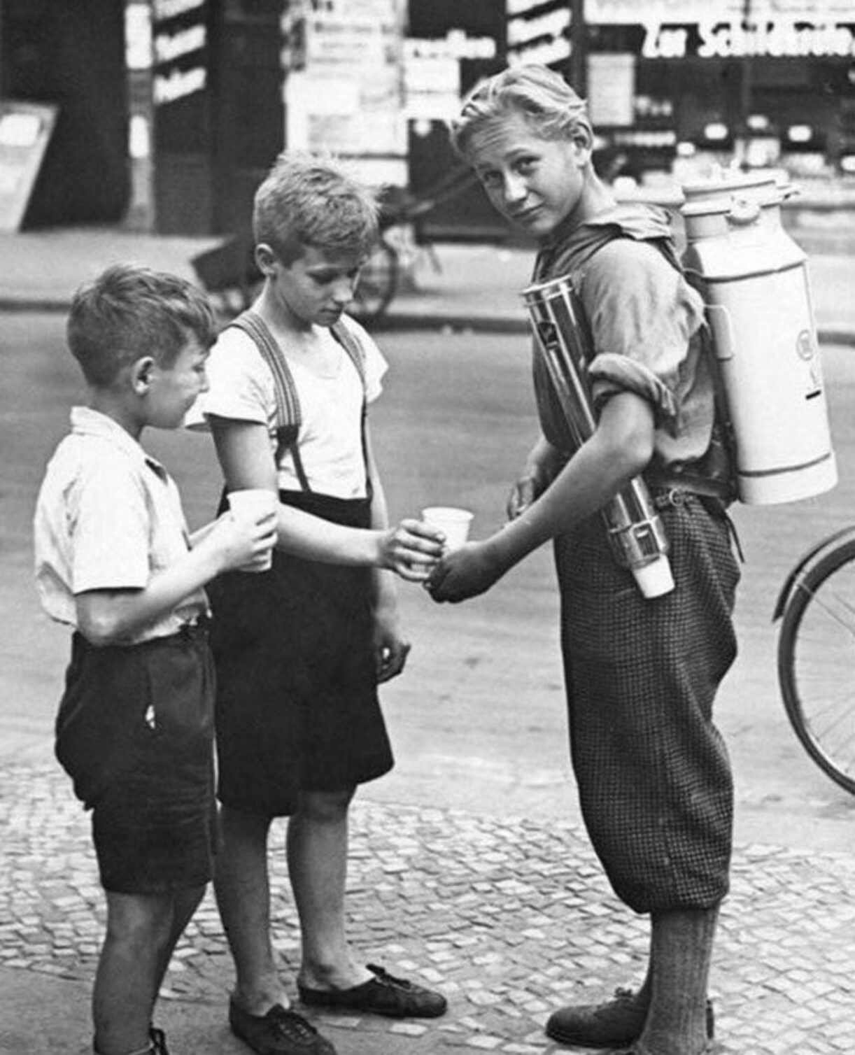 A boy selling lemonade with a portable lemonade dispenser. Berlin, 1931.