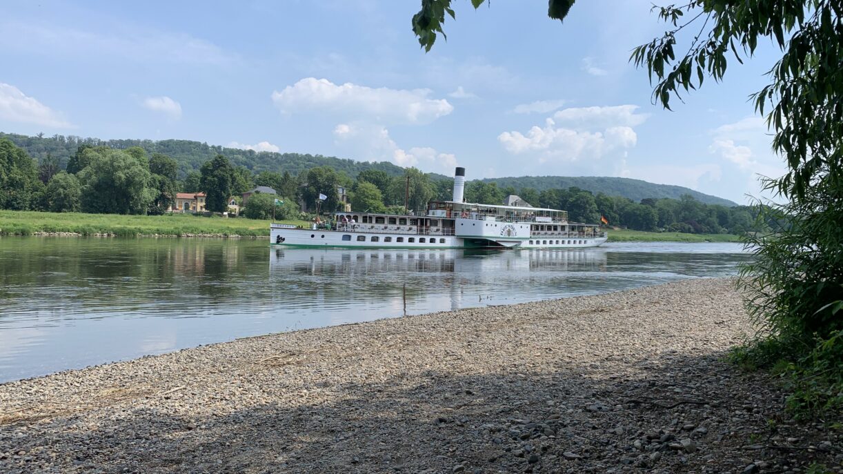 Ein Schaufelraddampfer schiebt sich die Elbe hinab